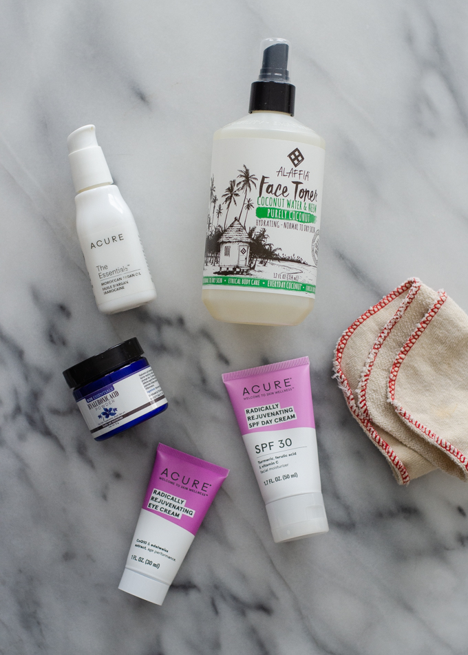 Products for a 5 step winter skin care routine for dry skin laid out on a marble surface.