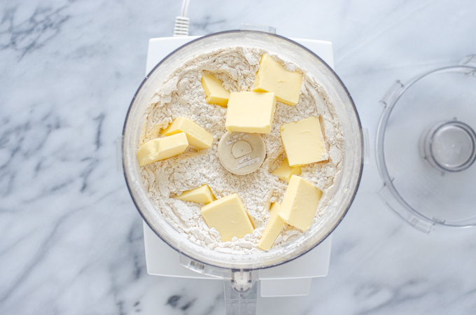 Adding the butter pieces to the food processor.