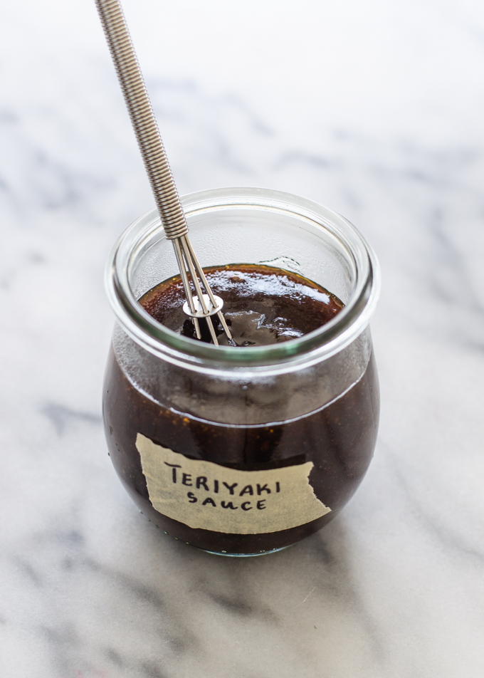 Homemade Teriyaki sauce in a small jar on a marble surface.