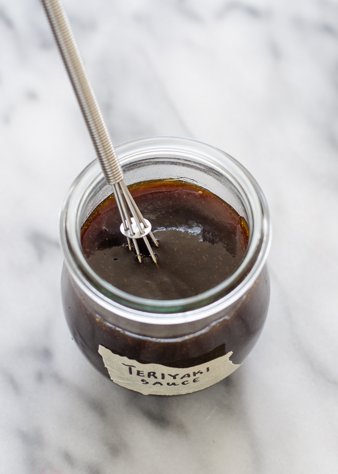 Homemade Teriyaki sauce in a small jar on a marble surface.