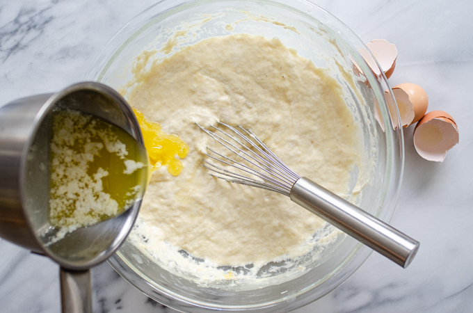 Pouring the butter into the sourdough pancake batter.