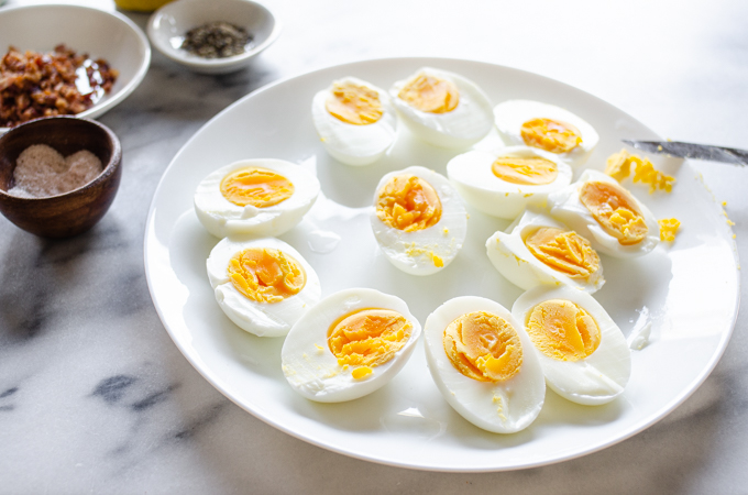 Hard boiled eggs sliced in half on a plate.