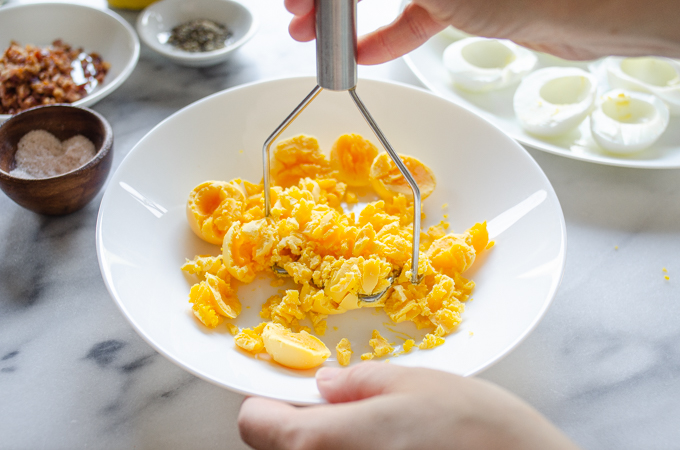 Mashing the egg yolks with a mini potato masher.