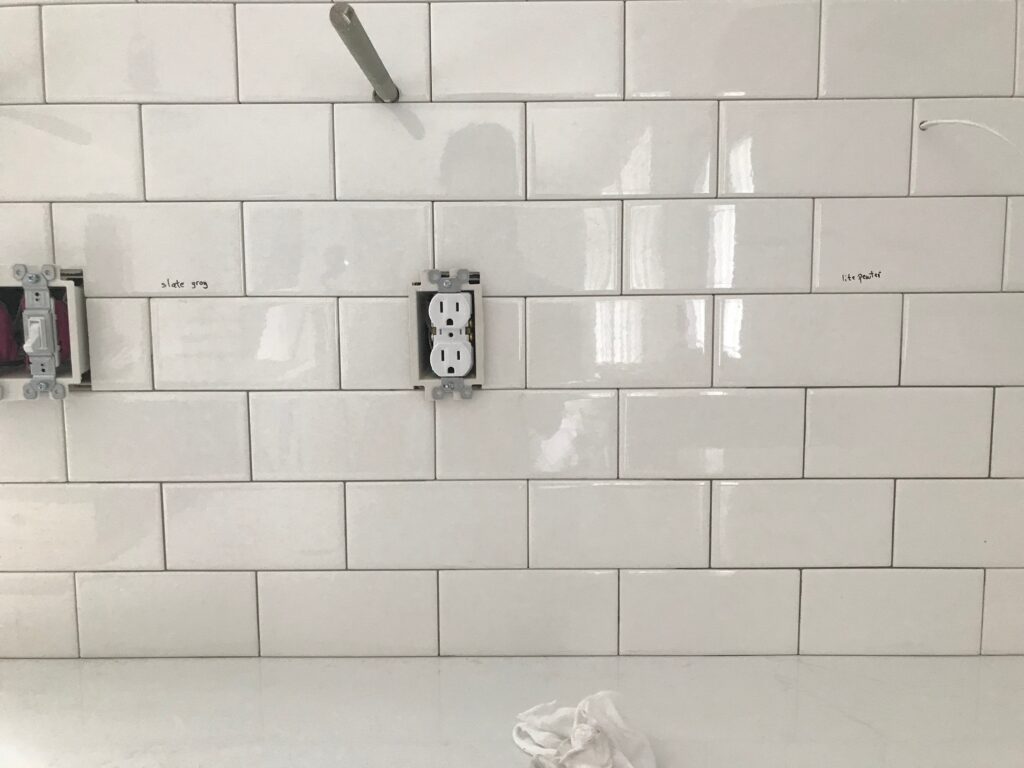 Choosing grout colors for a subway tile backsplash.