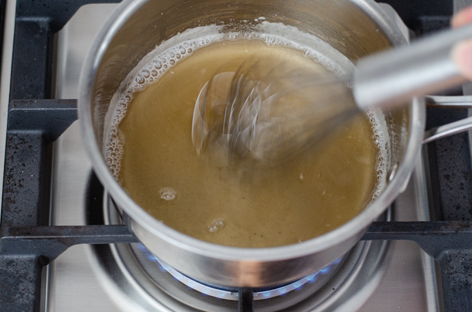 Whisking the maple syrup and gelatin mixture while cooking.