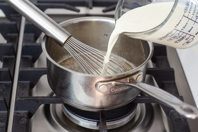 Pouring the cream into the other yogurt panna cotta ingredients.