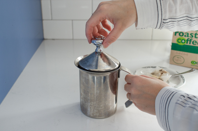 Frothing the milk with the hand pump milk frother.