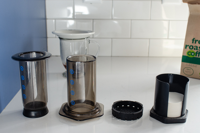 The parts of an aeropress coffee maker on a counter.