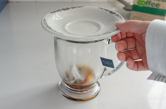 Putting a plate on the mug to retain the heat while the tea steeps.