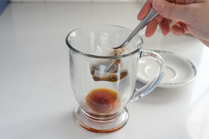 Squeezing out the chai tea bag into the mug.