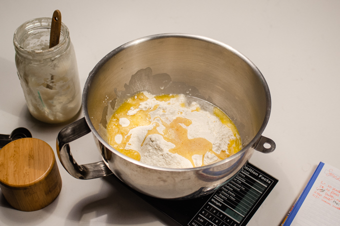 All of the ingredients for sourdough tortillas in the bowl of a stand mixer.