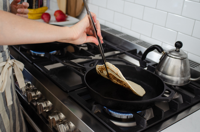 Flipping the tortilla over.