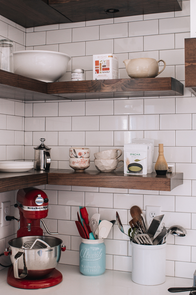 Open shelving with subway tile backsplash up to the ceiling. 