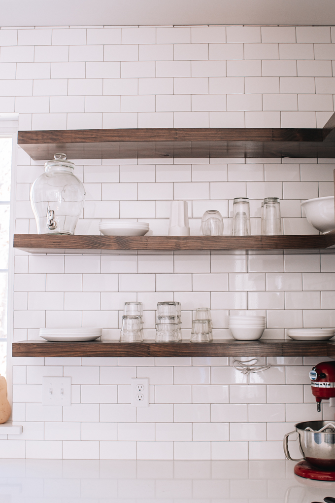 Open shelving in a transitional industrial modern farmhouse kitchen with subway tile backsplash up to the ceiling.