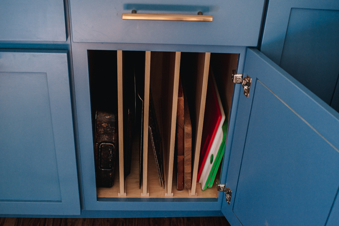 Divided storage in blue transitional industrial modern farmhouse kitchen cabinets.