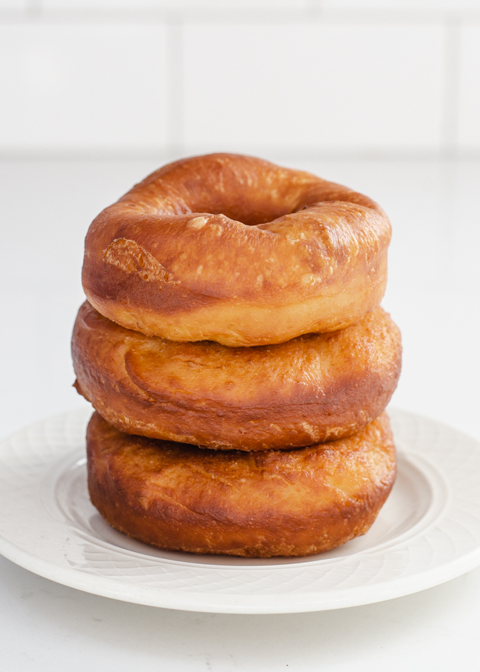 A stack of three donuts on a small plate made with my sourdough donut recipe.