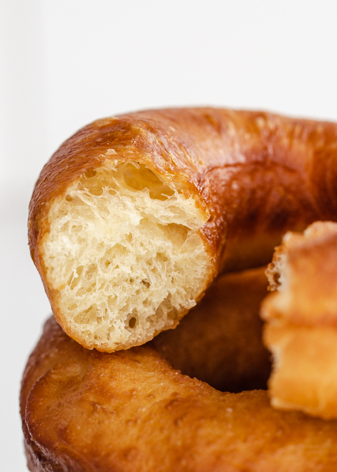 A bite taken out of a stack of three sourdough donuts.