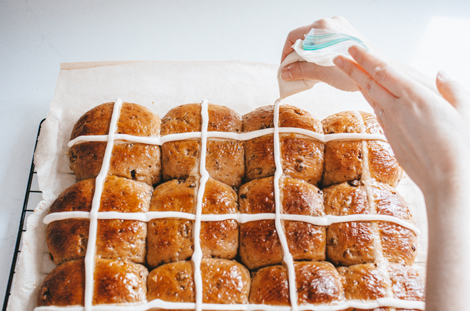 Piping the icing crosses onto the sourdough hot cross buns.