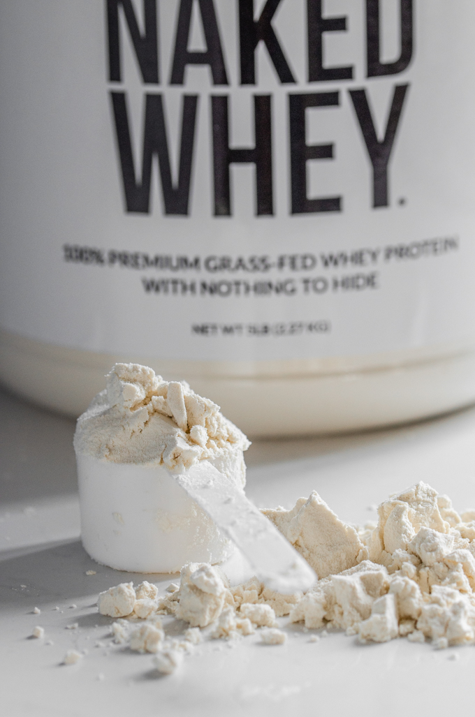 A scoop of grass-fed whey protein powder on a counter. 